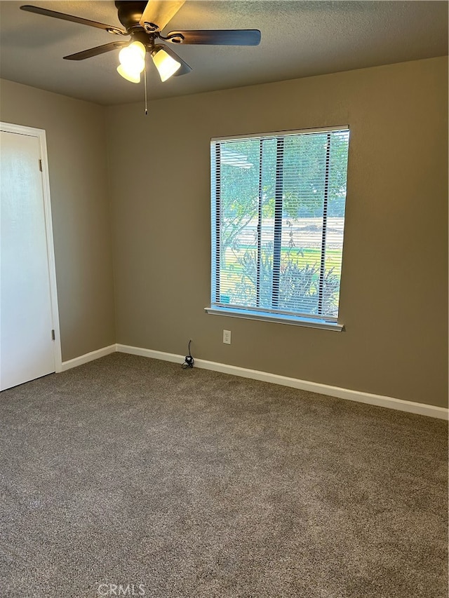 carpeted spare room with ceiling fan and a textured ceiling