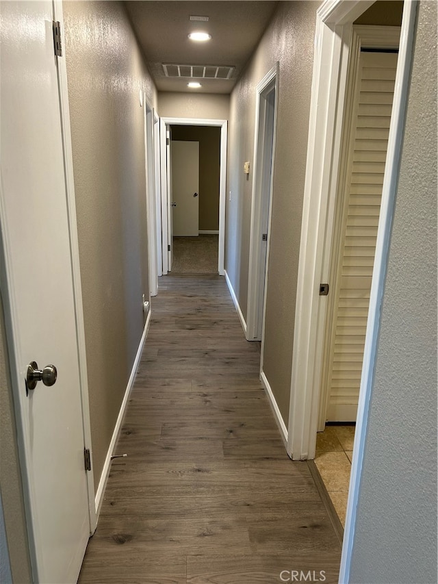 corridor with hardwood / wood-style flooring