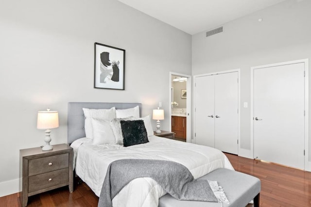 bedroom with dark hardwood / wood-style floors and connected bathroom