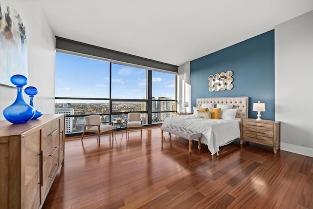 bedroom featuring expansive windows and dark hardwood / wood-style floors