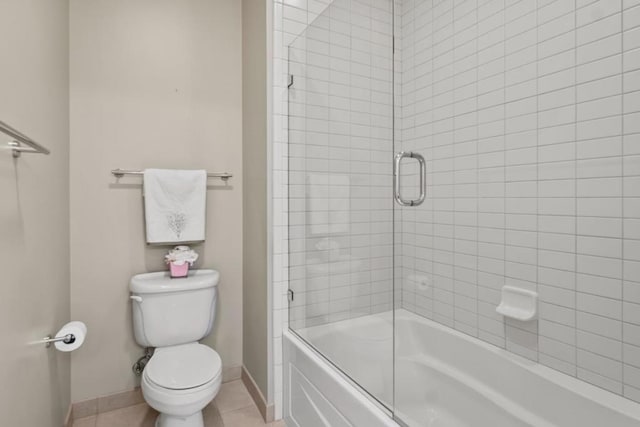 bathroom featuring shower / bath combination with glass door, tile patterned floors, and toilet