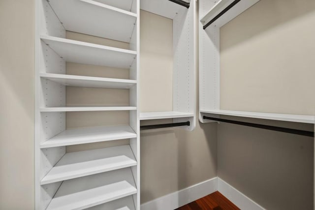 walk in closet with dark wood-type flooring