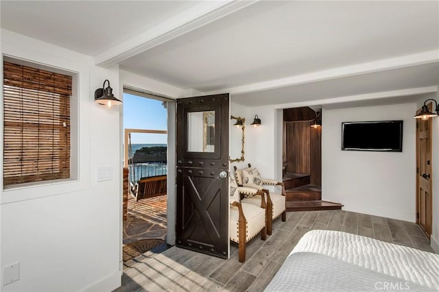 interior space with beam ceiling, baseboards, and wood finish floors