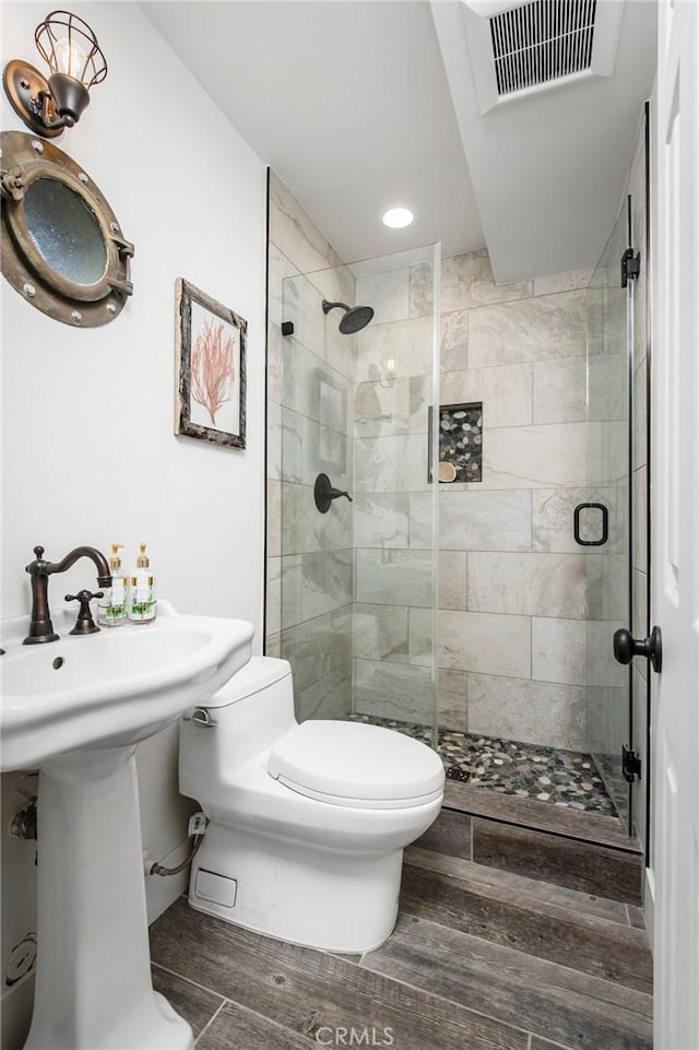 bathroom with a shower with door and toilet