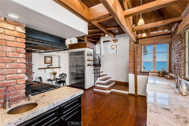 kitchen with stainless steel appliances, a water view, light stone countertops, and hanging light fixtures