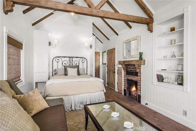 bedroom featuring a brick fireplace, lofted ceiling with beams, and hardwood / wood-style floors