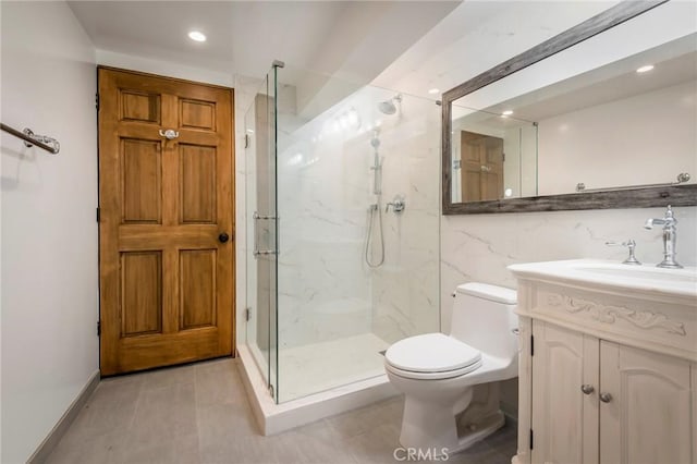 bathroom featuring tile patterned floors, toilet, vanity, and a shower with shower door