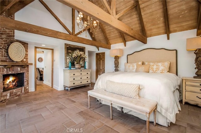 bedroom featuring baseboards, a chandelier, beamed ceiling, wood ceiling, and a fireplace