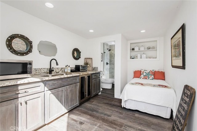 bedroom featuring connected bathroom and sink