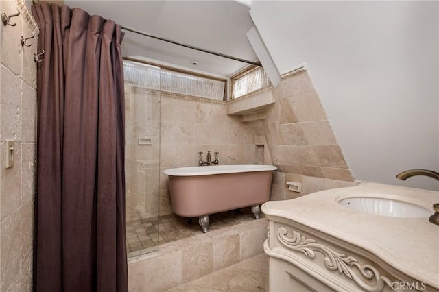 full bath featuring a soaking tub, curtained shower, tile walls, and vanity