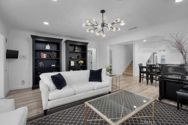 living room featuring light wood-type flooring and an inviting chandelier