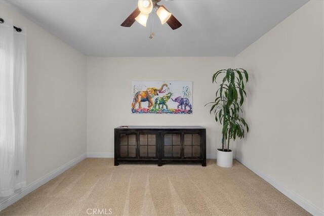 interior space with ceiling fan and light carpet