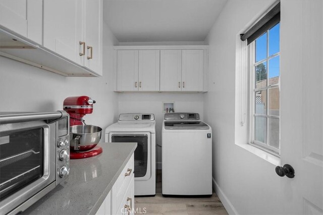 laundry area featuring light hardwood / wood-style flooring, cabinets, and independent washer and dryer