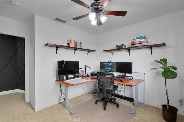 home office with ceiling fan and light carpet