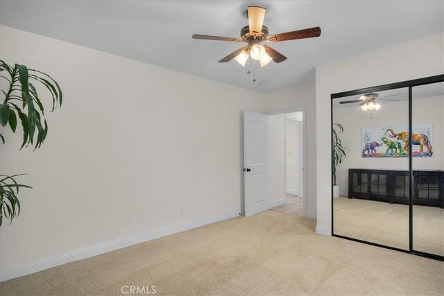 carpeted bedroom featuring ceiling fan and a closet