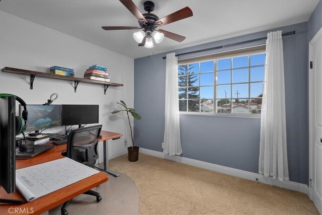 carpeted office space featuring ceiling fan