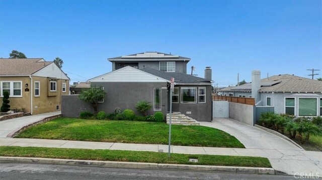 view of front of home with a front lawn and solar panels