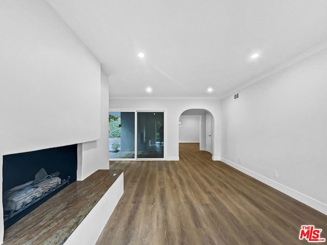 unfurnished living room featuring crown molding and dark hardwood / wood-style floors