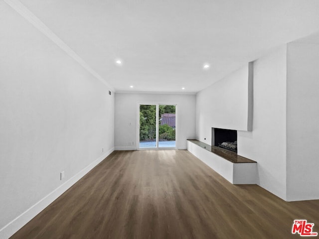 unfurnished living room with dark hardwood / wood-style flooring and ornamental molding