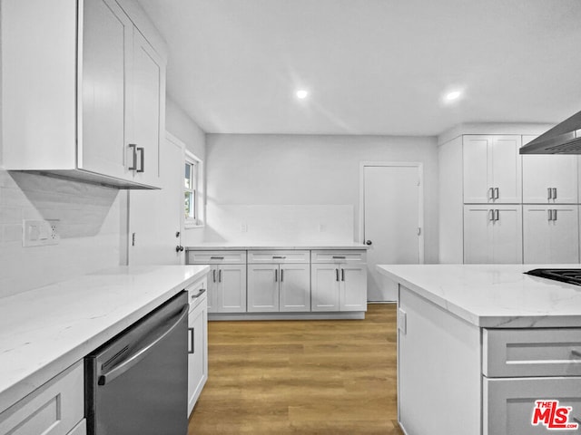 kitchen with light hardwood / wood-style flooring, stainless steel dishwasher, light stone countertops, tasteful backsplash, and white cabinetry