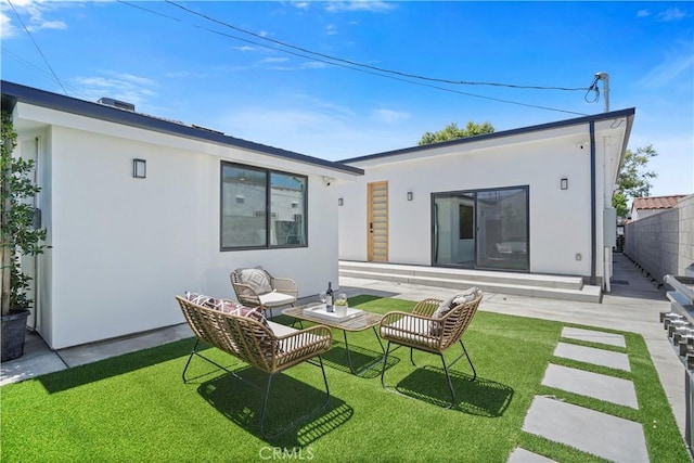 rear view of property with outdoor lounge area, a patio area, and a lawn