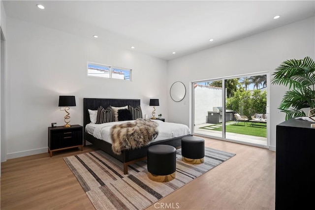 bedroom featuring light wood-type flooring and access to outside