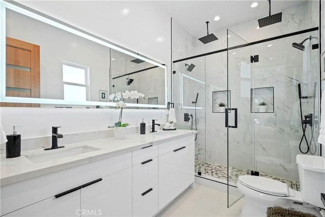 bathroom with toilet, vanity, and walk in shower