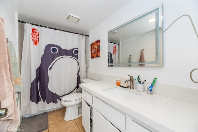 bathroom with tile patterned flooring, vanity, and toilet