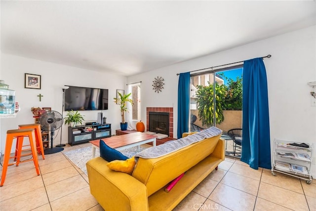 living room with light tile patterned floors and a brick fireplace