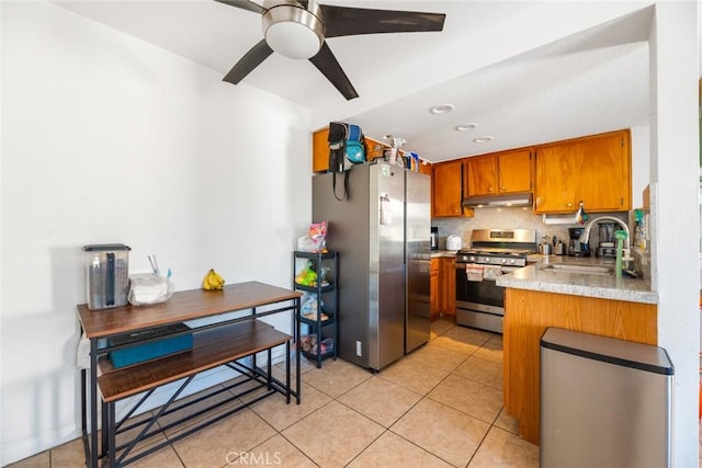 kitchen with tasteful backsplash, stainless steel appliances, ceiling fan, sink, and light tile patterned floors