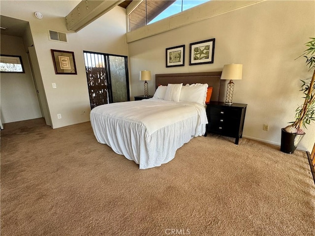 carpeted bedroom featuring beam ceiling and high vaulted ceiling