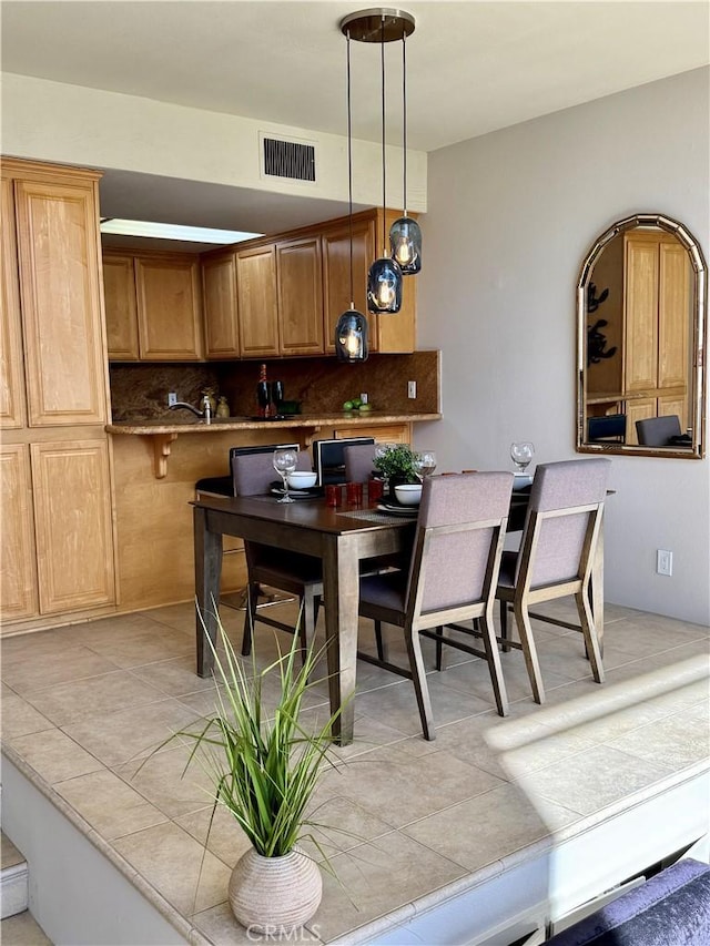 kitchen with decorative light fixtures, kitchen peninsula, and decorative backsplash