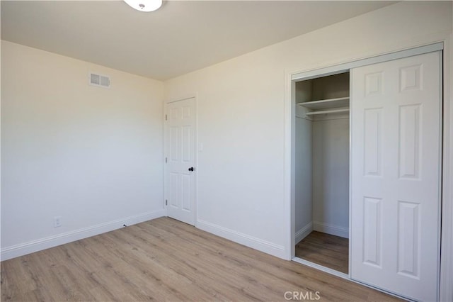 unfurnished bedroom with a closet and light hardwood / wood-style floors