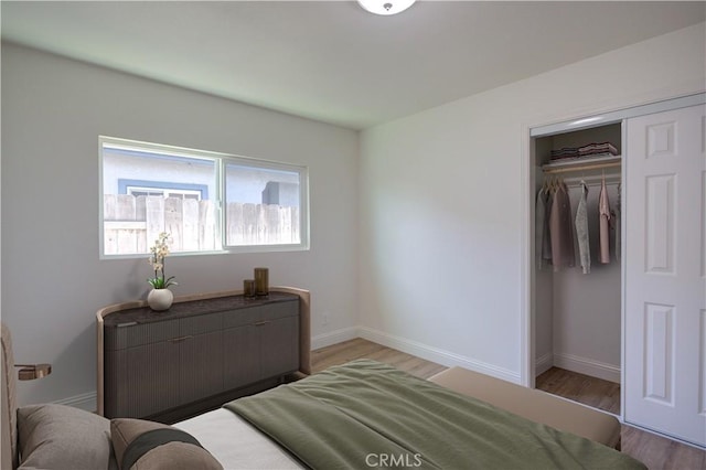 bedroom with light hardwood / wood-style flooring and a closet