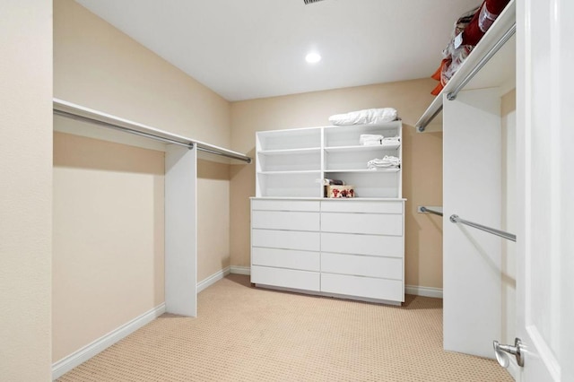 walk in closet featuring light carpet