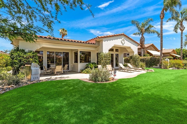 rear view of house featuring a yard and a patio