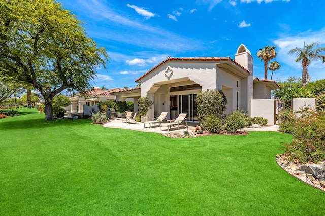 back of property featuring a yard and a patio