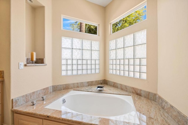 bathroom with a tub and vanity