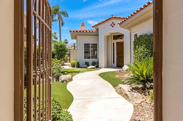 view of exterior entry with a lawn