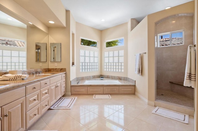 bathroom featuring plus walk in shower, tile patterned flooring, and vanity