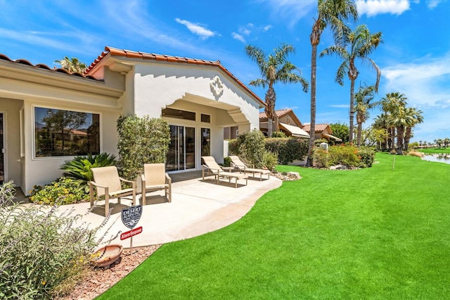 rear view of property with a lawn and a patio