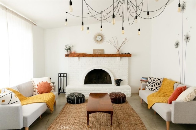 sitting room with a chandelier, a fireplace, and concrete floors