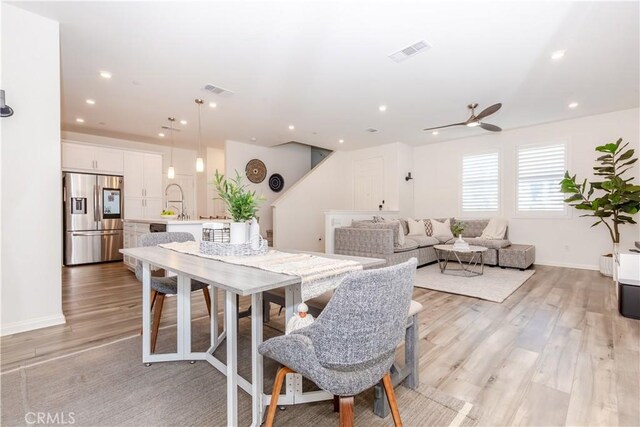 dining room featuring light hardwood / wood-style flooring, ceiling fan, and sink