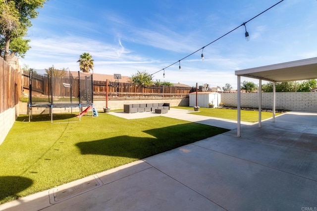 view of yard with an outdoor living space, a storage unit, a trampoline, and a patio