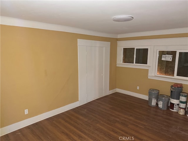 unfurnished bedroom featuring ornamental molding, dark hardwood / wood-style floors, and a closet