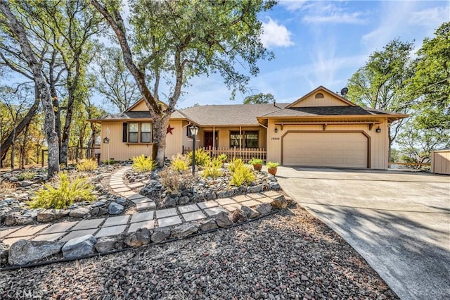 ranch-style home featuring covered porch and a garage