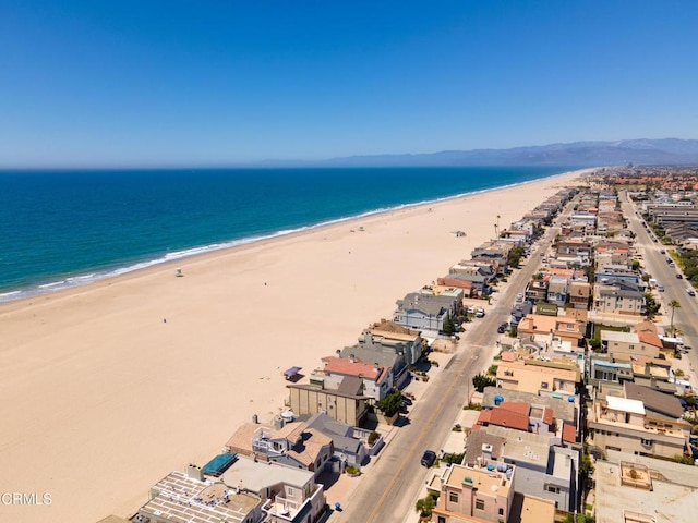 drone / aerial view featuring a water view and a view of the beach