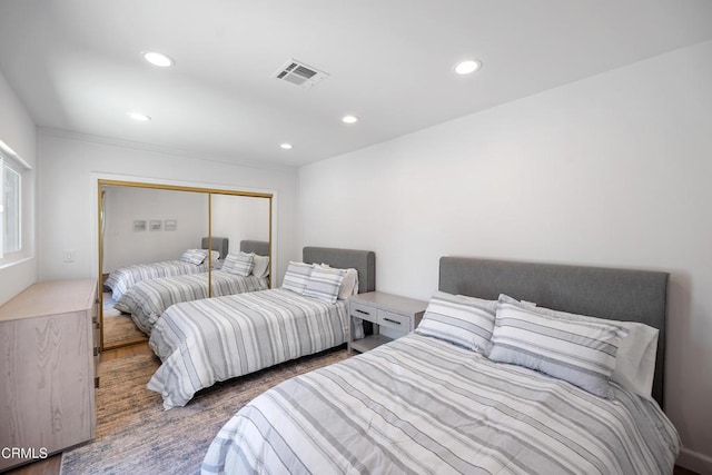 bedroom with a closet, visible vents, and recessed lighting