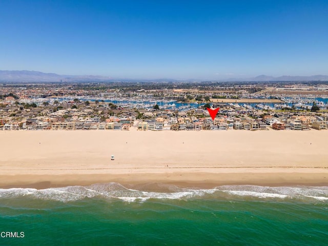 drone / aerial view featuring a beach view and a water view