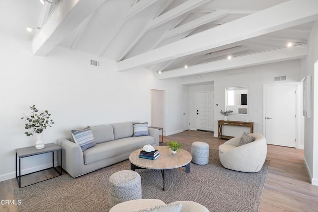 living area featuring wood finished floors, visible vents, and baseboards